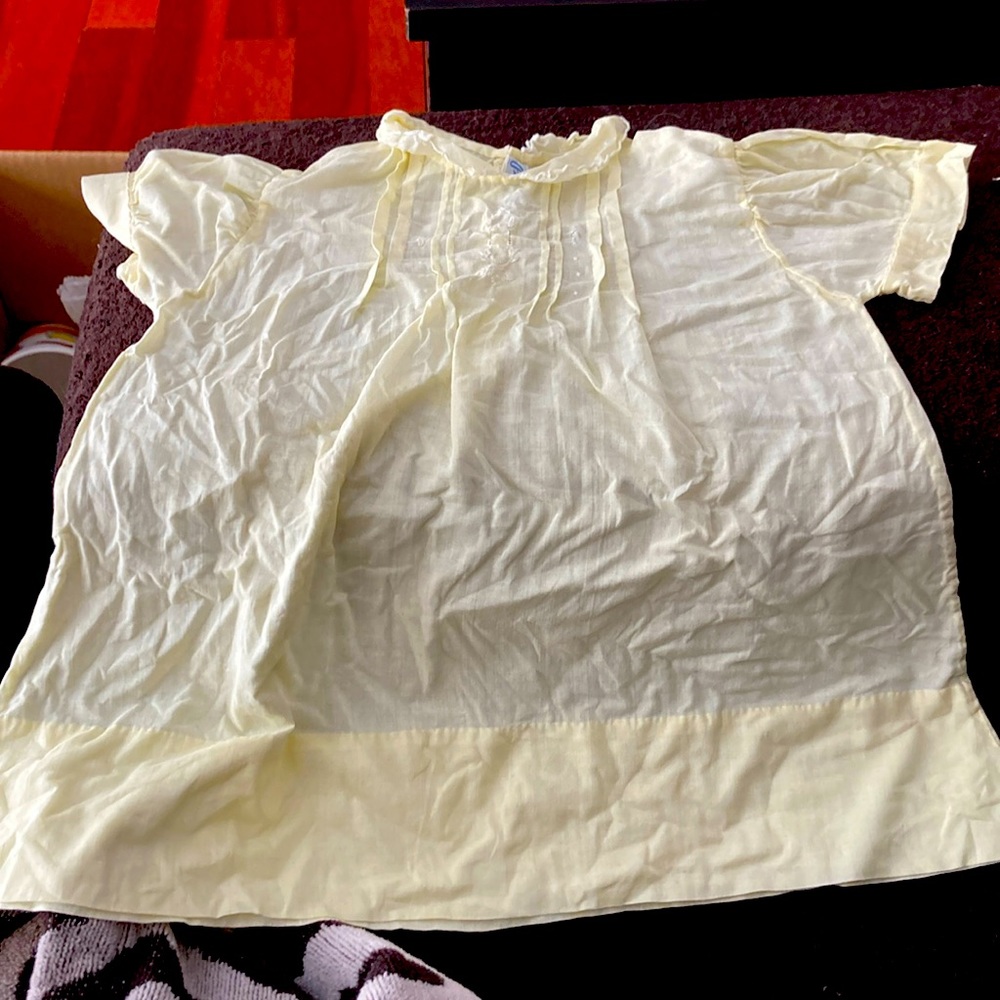 Soft yellow infant dress. Delicate features